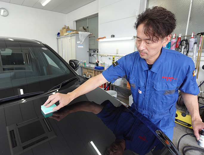 友進自動車のスタッフが鈑金塗装をしています